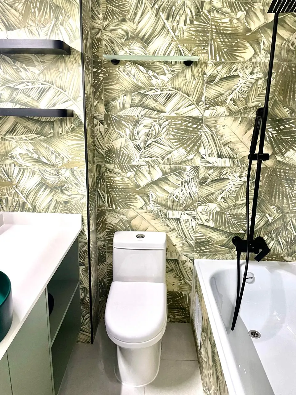 Baño completo con muro tropical, tina y vanitorio verde