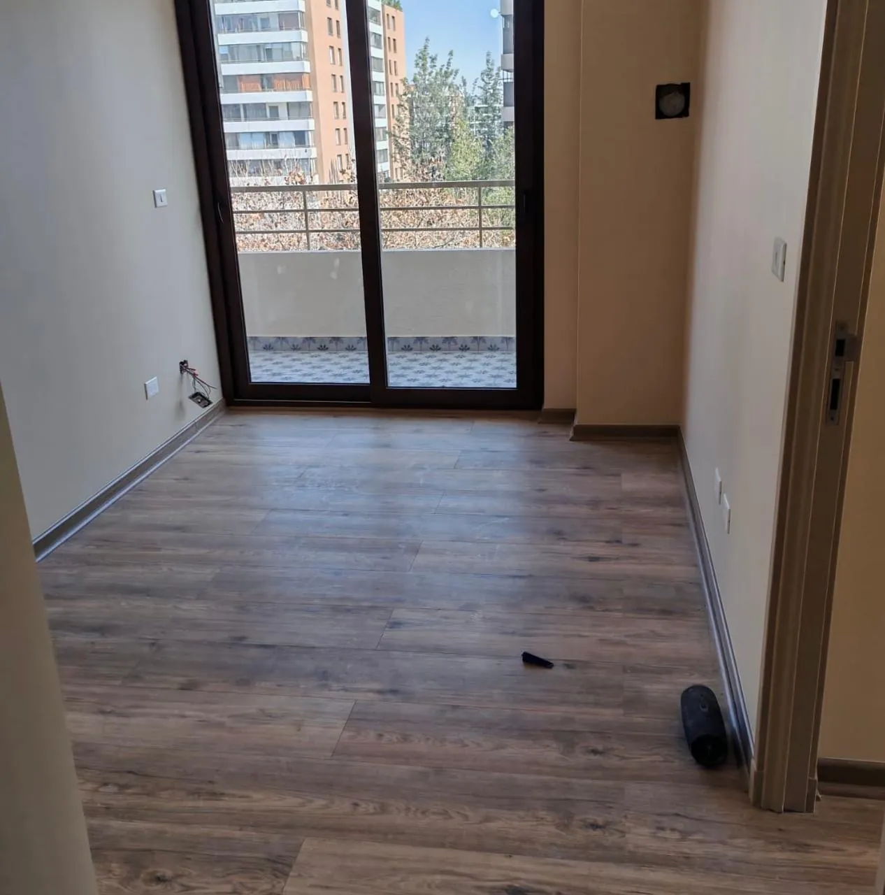 Dormitorio con piso flotante recién instalado y salida a terraza