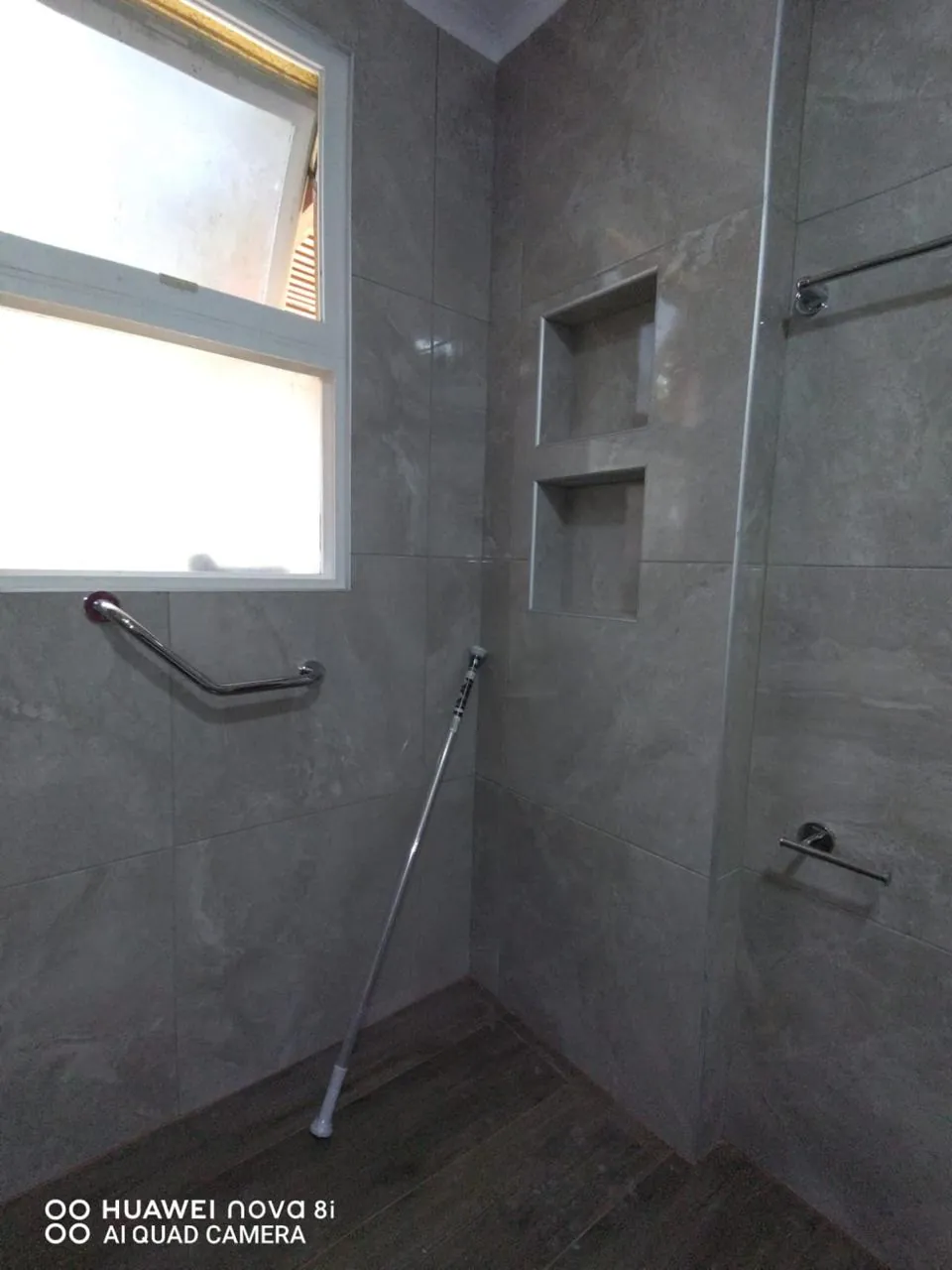 Ducha con porcelanato gris símil piedra y dos nichos empotrados