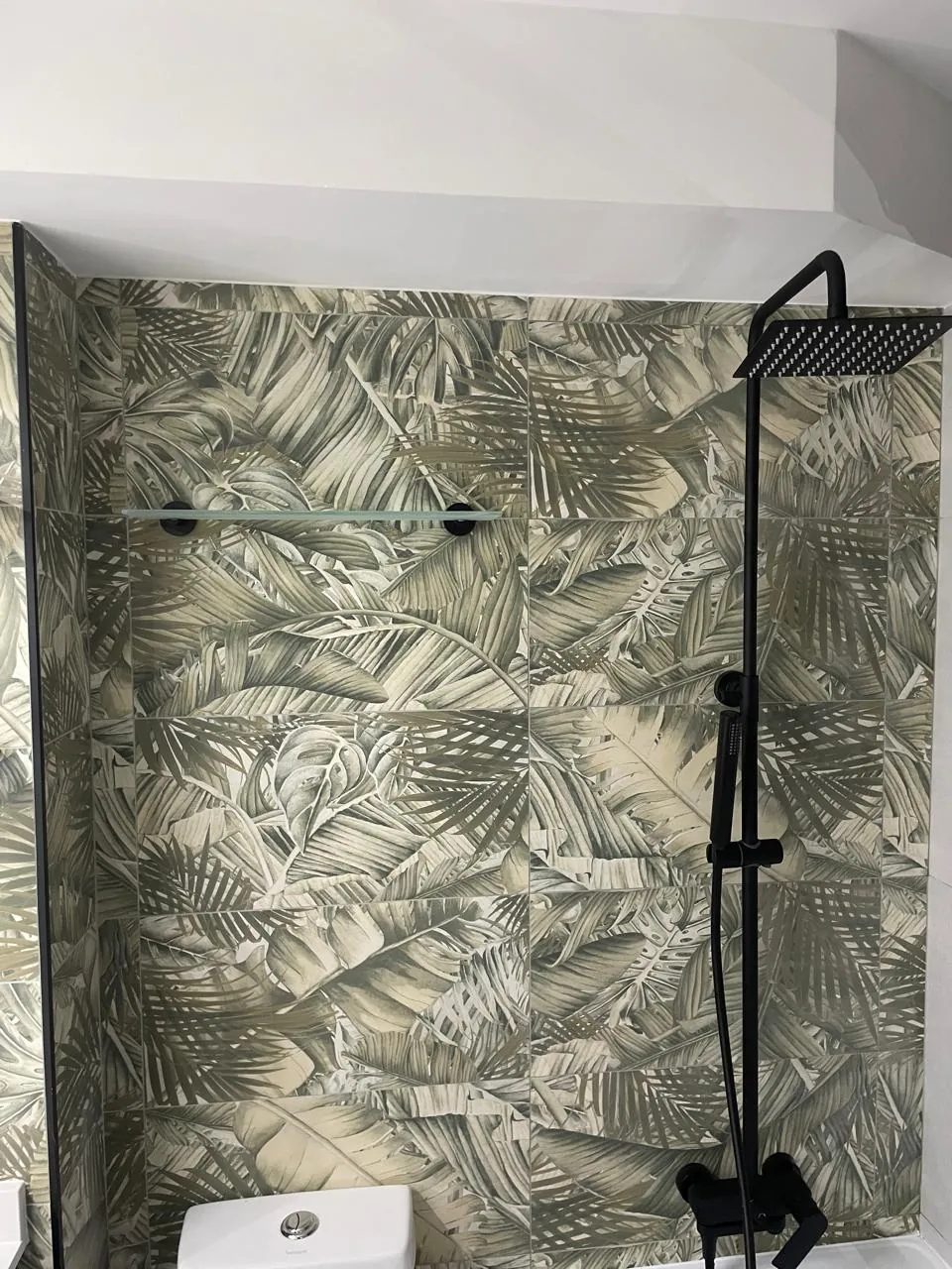 Muro de ducha en porcelanato tropical con repisa de vidrio
